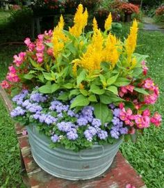 a bucket filled with lots of different colored flowers