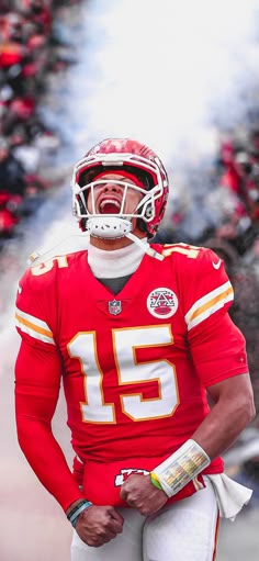 a man in a football uniform standing on the sidelines with his mouth wide open