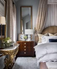 a bedroom with a bed, dresser and mirror on the wall next to each other