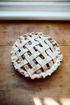 an apple pie sitting on top of a wooden table