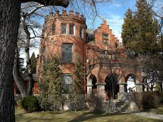 an old red brick building surrounded by trees