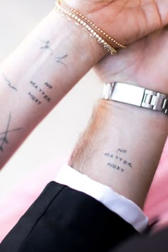 two people holding hands with tattoos on their wrists and wristbands that say no matter what they want