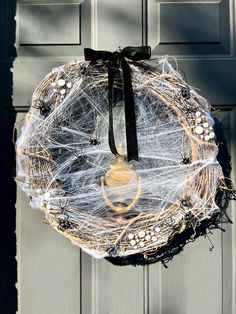 a wreath with spider webs and buttons hanging from the front door to give it a spooky look