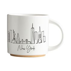 a white coffee mug with the new york skyline drawn on it