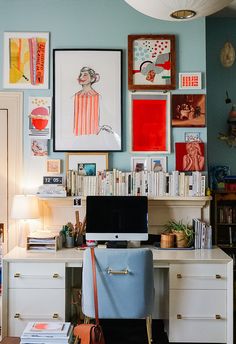 a home office with lots of art on the wall