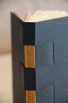 an open book sitting on top of a table next to a white and black object