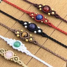 five different colored bracelets sitting on top of a cardboard box