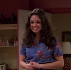 a woman standing in front of a kitchen counter with food on the table and she is smiling