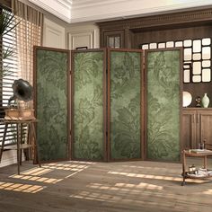 a room divider in the middle of a wood floored living room with green wallpaper