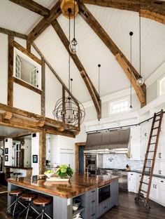 a large kitchen with wooden beams and white walls