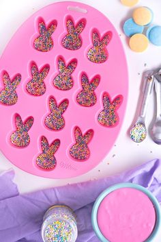 a pink cake pan with glitter hearts on it next to other baking utensils