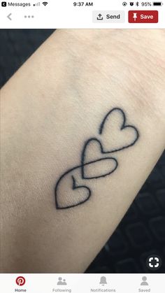 a heart tattoo on the wrist with two intertwined hearts