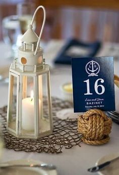 a table topped with a white lantern and a blue sign next to a rope ball