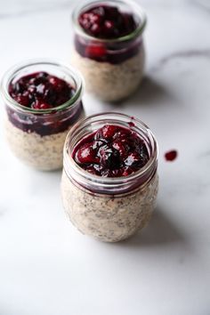 three jars filled with oatmeal and cranberry sauce