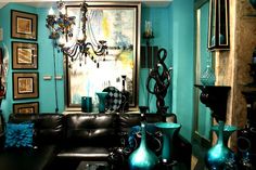 a living room filled with black furniture and blue walls