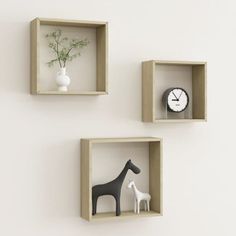 three wooden shelves with two different types of animals in them and a clock on the wall