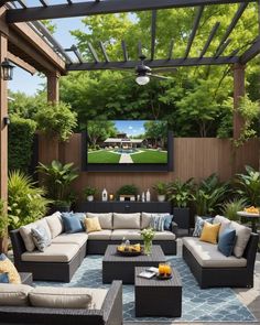 an outdoor living area with couches, tables and a flat screen tv on the wall