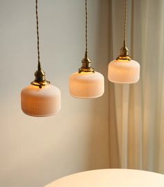 three light fixtures hanging from a ceiling in a room