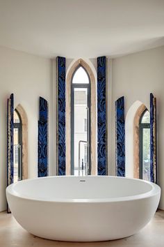 a large white bath tub sitting inside of a bathroom next to two arched doorways