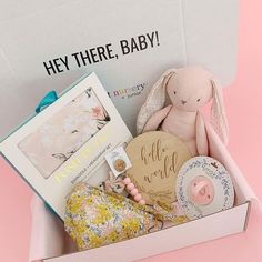 a pink box filled with baby items on top of a table