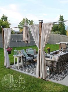 an outdoor living area with patio furniture and drapes on the side of the yard