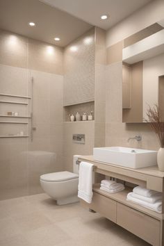 a white toilet sitting next to a sink in a bathroom under two lights on the wall