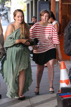 two women are walking down the street together