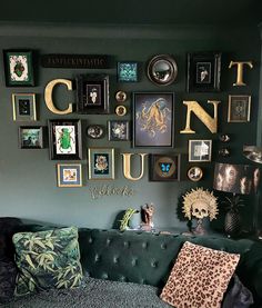 a living room filled with lots of framed pictures on the wall next to a couch