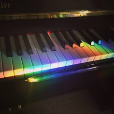 a close up of a piano with colorful lights on it