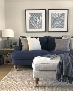 a living room with two pictures on the wall and a blue couch in front of it