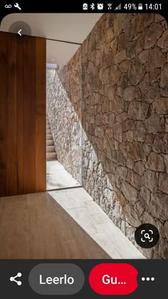 a stone wall next to a wooden door in a room with wood floors and walls