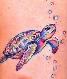 a colorful turtle tattoo on the side of a woman's thigh with water droplets around it