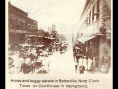 an old photo of horse and buggy parade in baysville note clock tower on courthouse in background