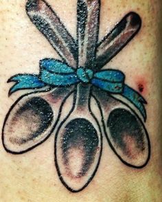 an image of a tattoo with spoons and utensils on the back of someone's neck