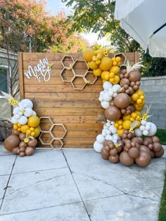 balloons are arranged in the shape of honeycombs and bees on a patio area