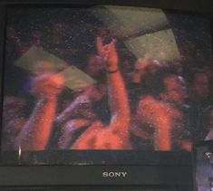 an old sony television with the image of people dancing on it's screen and holding their hands in the air