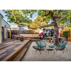 an outdoor deck with chairs and a tree