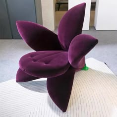 a purple flower shaped object sitting on top of a white surface in an office building