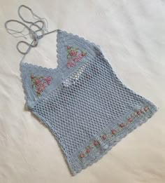 a crocheted blue piece of cloth with flowers on it