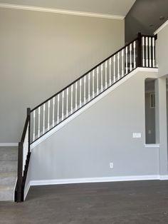 an empty living room with stairs leading up to the second floor and another door on the other side