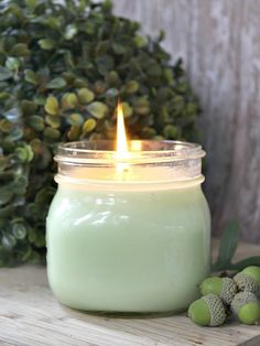 a green candle sitting on top of a wooden table