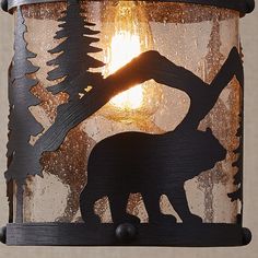 a light that has a bear on it and trees in the background with lights coming out