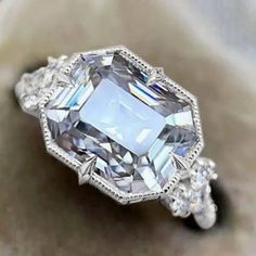 an engagement ring with a large diamond surrounded by smaller diamonds