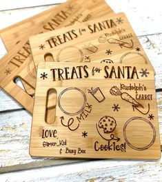 three wooden cutting boards with the words treats for santa written on them and images of cookies