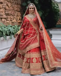 a woman in a red and gold bridal gown