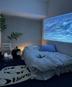 a bed room with a large screen on the wall and a plant in the corner