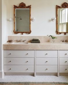 a bathroom with double sinks and two mirrors