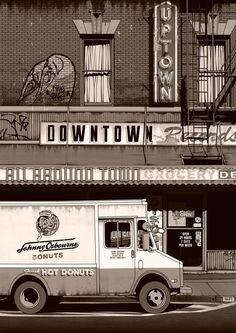 an old ice cream truck is parked in front of a building with the name down town written on it