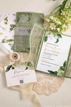 the wedding stationery is laid out on top of lace