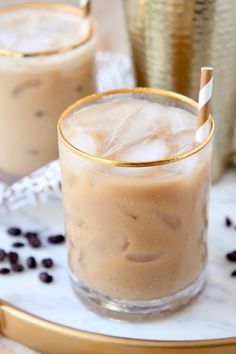 two glasses filled with iced coffee sitting on top of a table